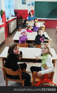 happy young teacher woman at elementrary school teaching and giving leassons to group of young smart children