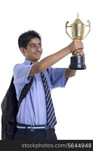 Happy young teenage boy holding trophy against white background