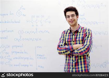 happy young teenage boy portrait in school on chemistry classes and library