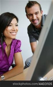 happy young woman and man working on laptop