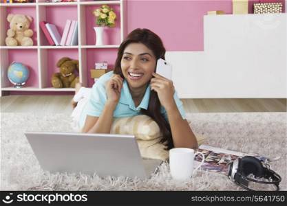 Happy young woman answering smart phone at home