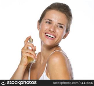 Happy young woman applying perfume