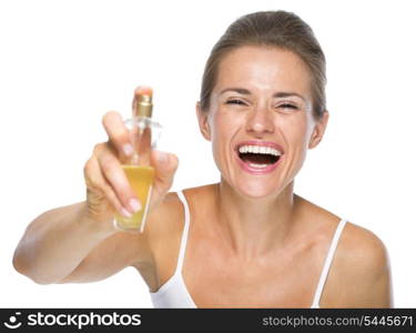 Happy young woman applying perfume in camera