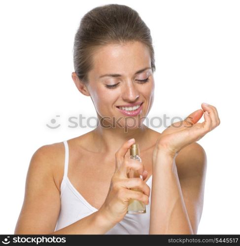Happy young woman applying perfume on hand