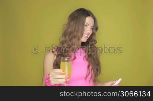 Happy young woman celebrating with an elegant glass of champagne as she drinks a birthday toast