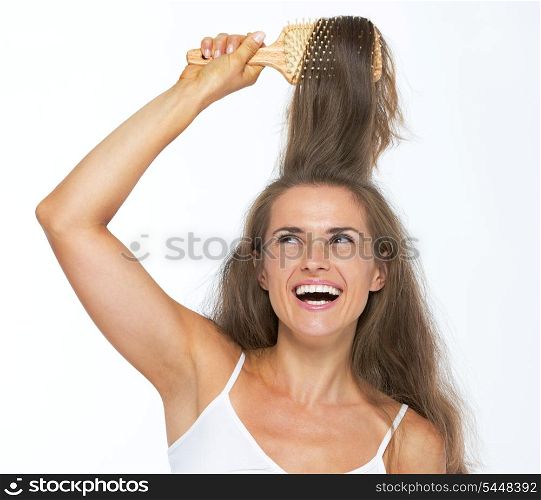 Happy young woman combing hair
