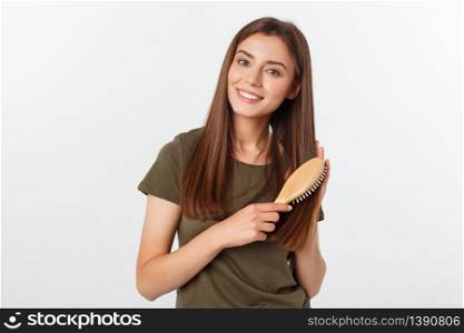 Happy young woman combing her long healthy hair on white background. Happy young woman combing her long healthy hair on white background.