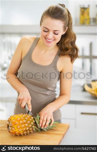 Happy young woman cutting pineapple