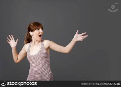 Happy young woman dancing and singing while listen music