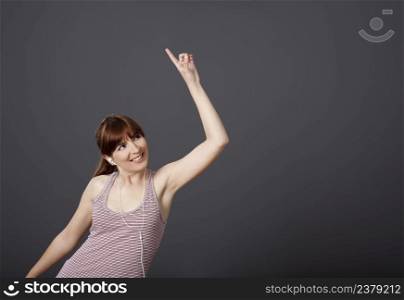 Happy young woman dancing and singing while listen music