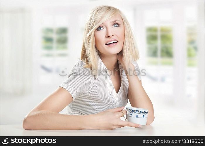 Happy young woman drinking coffee