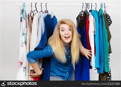 Happy young woman during shopping time picking clothes for perfect fashionable outfit.. Happy woman clothes shopping
