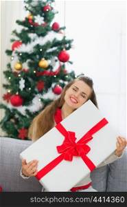 Happy young woman embracing big Christmas present box