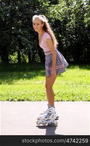 Happy young woman enjoying roller skating rollerblading on inline skates sport in park. Woman in outdoor activities