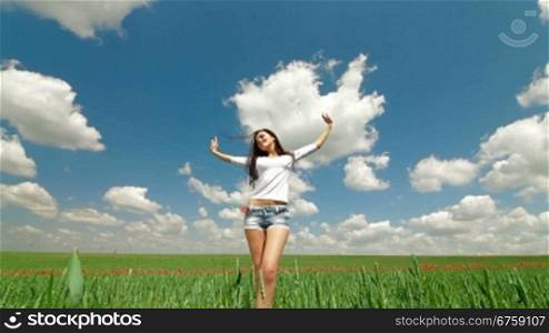 Happy Young Woman Enjoying Summer Day In A Green Wheat Field.