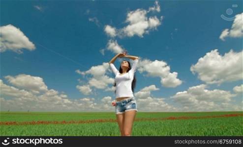 Happy Young Woman Enjoying Summer Day In A Green Wheat Field. Tracking shot