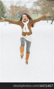 Happy young woman enjoying winter in park