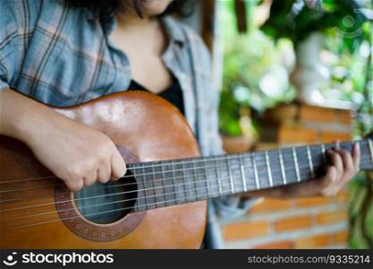 Happy young Woman hands playing acoustic guitar musician  alone compose instrumental song lesson on playing the guitar.