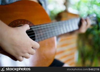 Happy young Woman hands playing acoustic guitar musician  alone compose instrumental song lesson on playing the guitar.