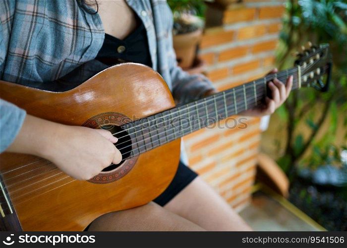 Happy young Woman hands playing acoustic guitar musician  alone compose instrumental song lesson on playing the guitar.