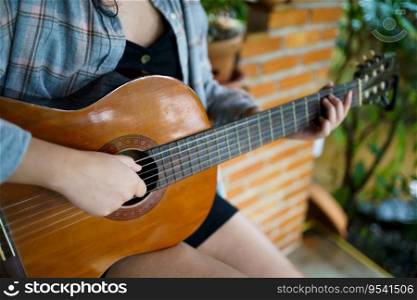 Happy young Woman hands playing acoustic guitar musician  alone compose instrumental song lesson on playing the guitar.