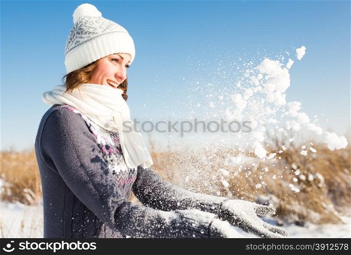 Happy young woman have fun and enjoy fresh snow at beautiful winter day