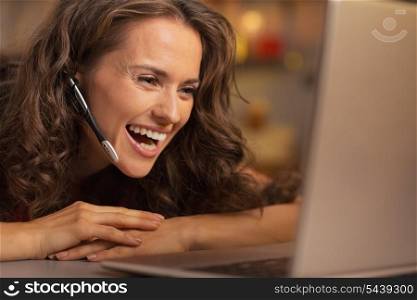 Happy young woman having christmas video chat on laptop