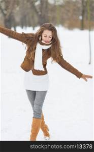 Happy young woman having fun in winter outdoors