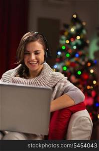 Happy young woman having video chat with family in front of Christmas tree