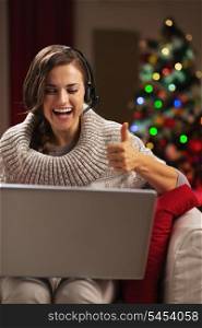 Happy young woman having video chat with family in front of christmas tree