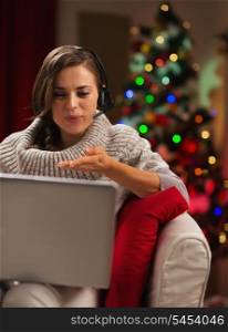 Happy young woman having video chat with lover in front of Christmas tree