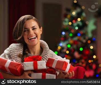 Happy young woman holding Christmas present boxes