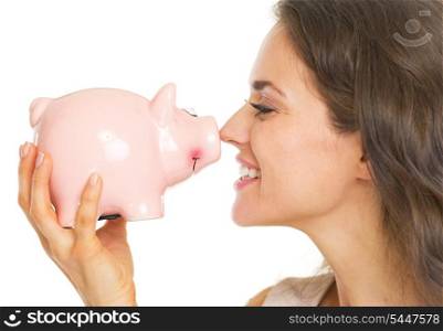 Happy young woman holding piggy bank