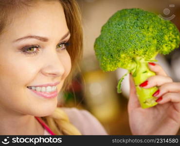 Happy young woman holding raw green vegetable broccoli. Natural organic healthy food concept.. woman holding broccoli vegetable