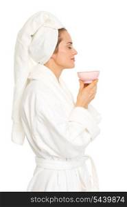 Happy young woman in bathrobe enjoying cup of coffee