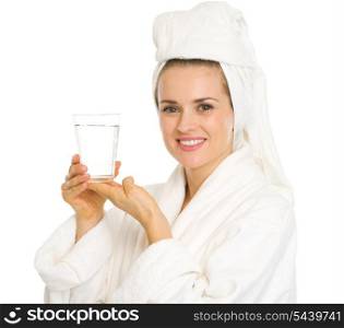 Happy young woman in bathrobe holding glass of water