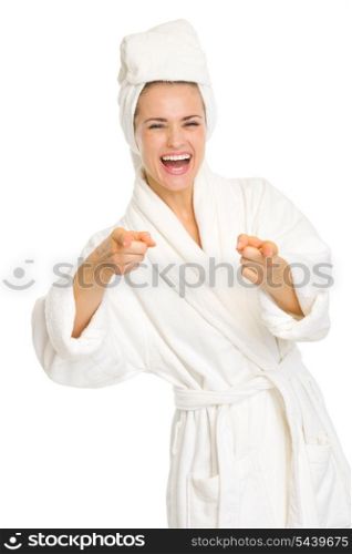 Happy young woman in bathrobe pointing in camera