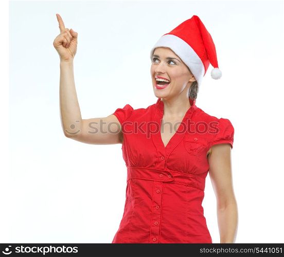 Happy young woman in Christmas hat pointing up