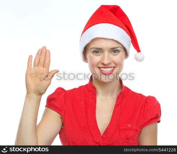 Happy young woman in Christmas hat saluting