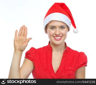 Happy young woman in Christmas hat saluting