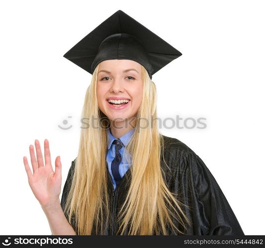 Happy young woman in graduation gown greeting