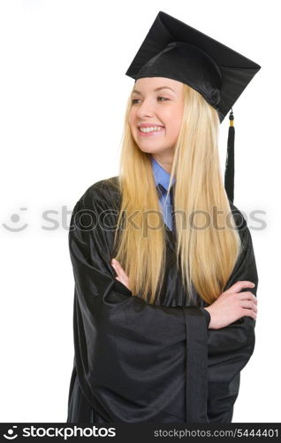 Happy young woman in graduation gown looking on copy space