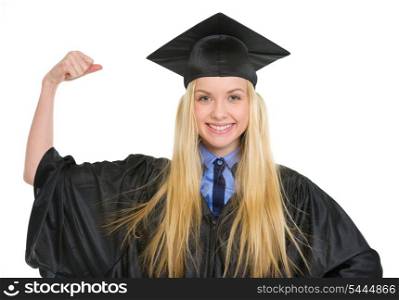Happy young woman in graduation gown showing biceps