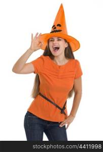 Happy young woman in Halloween hat showing ok gesture