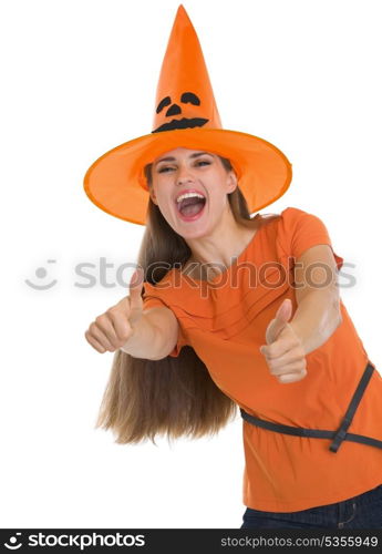 Happy young woman in Halloween hat showing thumbs up