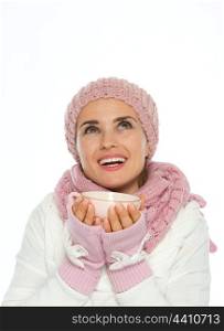 Happy young woman in knit winter holding cup and looking up on copy space