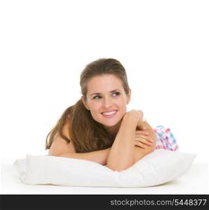 Happy young woman in pajamas laying on pillow and looking on copy space