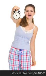 Happy young woman in pajamas showing alarm clock