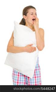 Happy young woman in pajamas with pillow yawing