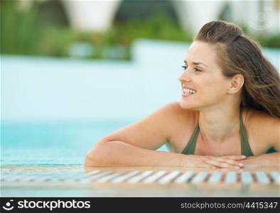 Happy young woman in pool looking on copy space